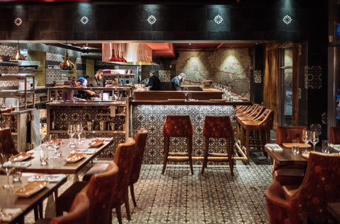 Interior view of Damas restaurant with warm lighting, upholstered seating, and decorative elements reflecting a Middle Eastern theme.